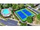 Aerial view of a community pool and two blue tennis courts with green surroundings at 2425 Delamore Chase, Duluth, GA 30097