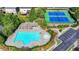 An aerial view of a pool area with a main pool, kiddie pool, and two tennis courts at 2425 Delamore Chase, Duluth, GA 30097