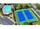 Overhead view of a community pool and a pair of brightly colored tennis courts at 2425 Delamore Chase, Duluth, GA 30097