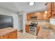 Well-lit kitchen with stainless steel appliances, wood cabinets, and tile backsplash, providing a functional cooking space at 3395 Spring Dr, Atlanta, GA 30360
