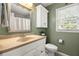Traditional bathroom features a toilet, window, and sink with a framed mirror above at 3999 Brintons Ml, Marietta, GA 30062