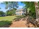 Beautiful two-story home with lush landscaping, mature trees, and a park bench at 3999 Brintons Ml, Marietta, GA 30062