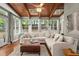 Bright sunroom with wood ceiling, skylights, and oversized cream-colored sectional sofa at 3999 Brintons Ml, Marietta, GA 30062
