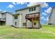 Back of house with a small elevated deck overlooking a grassy lawn and tree line at 7760 Hansel Ln, Lithonia, GA 30058