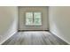 Bright bedroom features a large window and modern gray wood flooring at 7760 Hansel Ln, Lithonia, GA 30058