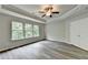 Bedroom features three large windows providing a view of the outdoors and gray laminate flooring at 7760 Hansel Ln, Lithonia, GA 30058