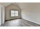 Bedroom featuring vaulted ceilings and wood-look flooring, with a sunny window at 7760 Hansel Ln, Lithonia, GA 30058