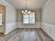 Elegant dining room with modern chandelier, gray walls, and large windows at 7760 Hansel Ln, Lithonia, GA 30058