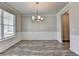 Elegant dining room with modern chandelier, gray walls, and large windows at 7760 Hansel Ln, Lithonia, GA 30058