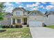 Charming two-story home features a covered front porch and attached two car garage at 7760 Hansel Ln, Lithonia, GA 30058