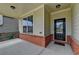 Covered front porch with brick accents leads to the front door of the home at 7760 Hansel Ln, Lithonia, GA 30058