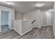 Upstairs hallway with modern lighting and gray wood floors at 7760 Hansel Ln, Lithonia, GA 30058