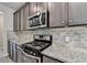 Modern kitchen featuring granite countertops, stainless steel appliances, and a stylish backsplash at 7760 Hansel Ln, Lithonia, GA 30058