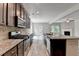 A modern kitchen features stainless appliances, granite countertops, and open layout to the living area at 7760 Hansel Ln, Lithonia, GA 30058