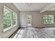 Bright living room with large windows and wood floors, offering a view of the surrounding greenery at 7760 Hansel Ln, Lithonia, GA 30058