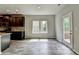 Open floor plan with a view of the modern kitchen, large windows, and a door leading to the outside deck at 7760 Hansel Ln, Lithonia, GA 30058