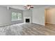 Open concept living area with wood floors, fireplace, ceiling fan, with a view of the surrounding trees at 7760 Hansel Ln, Lithonia, GA 30058