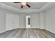 Main bedroom boasts trey ceilings, ceiling fan, gray wood style flooring, and en-suite access at 7760 Hansel Ln, Lithonia, GA 30058