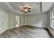 Bright main bedroom showcasing trey ceilings, ceiling fan, and gray wood style flooring at 7760 Hansel Ln, Lithonia, GA 30058