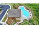 Aerial view of community pool with lounge chairs and tables surrounded by lush landscaping near a parking area at 7760 Hansel Ln, Lithonia, GA 30058