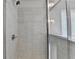 Enclosed tiled shower with window next to it, as well as a chrome shower head at 7760 Hansel Ln, Lithonia, GA 30058