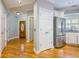 Hallway featuring gleaming hardwood floors, white trim, and a stainless steel refrigerator at 8650 Hope Mews Ct, Sandy Springs, GA 30350