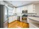 Updated kitchen with stainless steel appliances and white cabinets, and hardwood floors at 8650 Hope Mews Ct, Sandy Springs, GA 30350