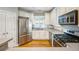 Bright kitchen featuring white cabinets, stainless steel appliances, and hardwood flooring at 8650 Hope Mews Ct, Sandy Springs, GA 30350