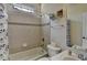 Well-lit bathroom featuring tile surround, bathtub, and white fixtures at 2123 Floral Ridge Dr, Dacula, GA 30019