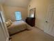 Cozy bedroom with beige carpet, complementary colored walls and dresser, and a sunny window at 2123 Floral Ridge Dr, Dacula, GA 30019