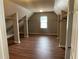 Walk-in closet featuring custom shelving, hardwood floors, and neutral paint at 2123 Floral Ridge Dr, Dacula, GA 30019