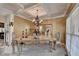Elegant dining room features a coffered ceiling, ornate chandelier, and large windows for natural light at 2123 Floral Ridge Dr, Dacula, GA 30019