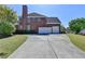 Brick home featuring a three-car garage and long driveway at 2123 Floral Ridge Dr, Dacula, GA 30019
