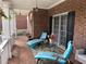 Charming front porch with brick flooring, white columns, outdoor furniture, and decorative accents at 2123 Floral Ridge Dr, Dacula, GA 30019