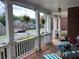 Inviting front porch with brick flooring, white columns, outdoor furniture, and hanging plants at 2123 Floral Ridge Dr, Dacula, GA 30019