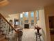 Elegant living room featuring tall windows, a fireplace, and a staircase with wrought iron railings at 2123 Floral Ridge Dr, Dacula, GA 30019