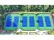 Aerial view of six well-maintained tennis courts with blue and green surfaces, surrounded by lush greenery at 2123 Floral Ridge Dr, Dacula, GA 30019