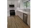Modern kitchen featuring white cabinetry, stainless steel appliances, and light wood flooring at 2645 Trotters Walk Trl, Snellville, GA 30078