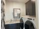 Functional laundry room with washer, dryer, utility sink and dark cabinets at 750 Keystone Dr, Woodstock, GA 30188