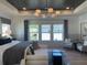 Well-lit primary bedroom with seating area, a stylish ceiling fan and three large windows at 750 Keystone Dr, Woodstock, GA 30188