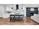 Open kitchen with modern island, white cabinets, stylish lighting, and contrasting dark brick fireplace at 3420 Burnt Hickory Nw Rd, Marietta, GA 30064