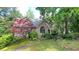 Charming home featuring a stone facade, arched entry, dormer windows, and lush, mature landscaping at 5357 Steeple Chase, Douglasville, GA 30135