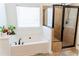 Bright bathroom features a soaking tub, a separate glass enclosed shower with a rain shower head at 6175 Beaver Crossing Dr, Cumming, GA 30040