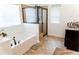 Bathroom with a soaking tub, a glass enclosed shower and a vanity with dark cabinets at 6175 Beaver Crossing Dr, Cumming, GA 30040