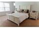 Bright bedroom with carpet floors, a queen-sized bed with a white frame, two bedside tables, and a sunny window at 6175 Beaver Crossing Dr, Cumming, GA 30040