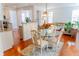Open-concept dining area with a glass table, stylish chairs, and connection to the kitchen and living room at 6175 Beaver Crossing Dr, Cumming, GA 30040