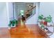 Bright foyer featuring hardwood floors, a staircase with iron railings, and decorative plants at 6175 Beaver Crossing Dr, Cumming, GA 30040
