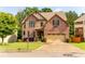 Beautiful two-story brick home with well-manicured lawn, mature trees, and a two-car garage at 6175 Beaver Crossing Dr, Cumming, GA 30040