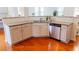 Well-lit kitchen with white cabinets, granite countertops, stainless steel dishwasher, and hardwood floors at 6175 Beaver Crossing Dr, Cumming, GA 30040