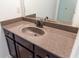 A granite topped single sink vanity with dark wood cabinets and a framed mirror at 6175 Beaver Crossing Dr, Cumming, GA 30040